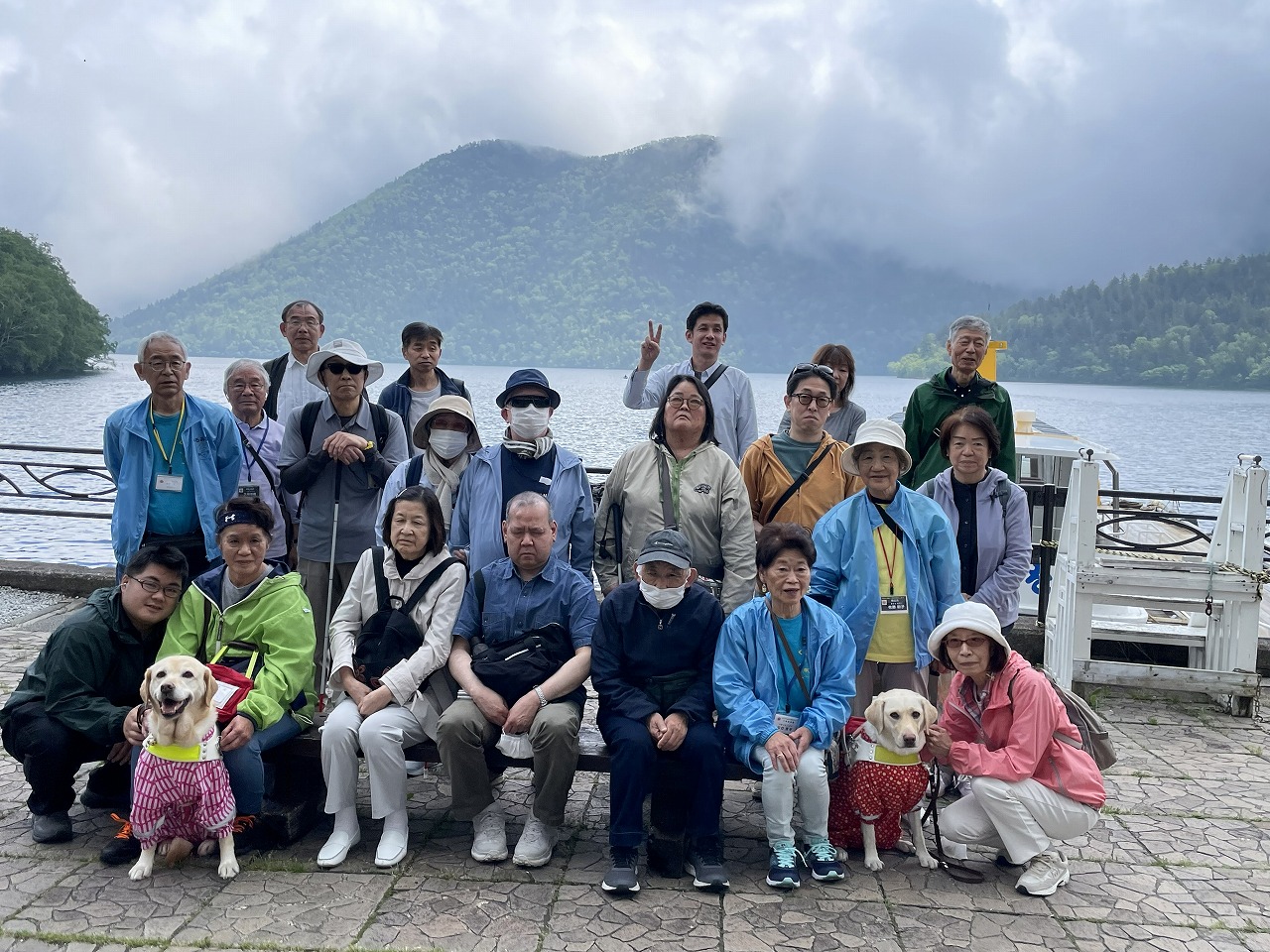 湖を背に集合写真　唇山がバックに見えています